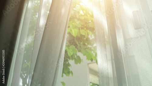 Obraz na płótnie Opening the curtains to let in natural sunlight fills the room with warmth and brightness, supporting a healthy, cheerful home environment that enhances both mood and overall well-being