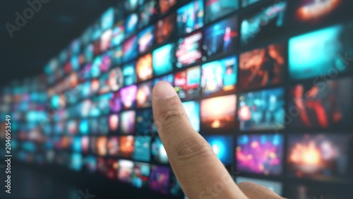 Photos Using a fingertip gesture to navigate entertainment on a big TV showcases touchless technology, digital convenience, user empowerment, smart homes, and personalized media experiences