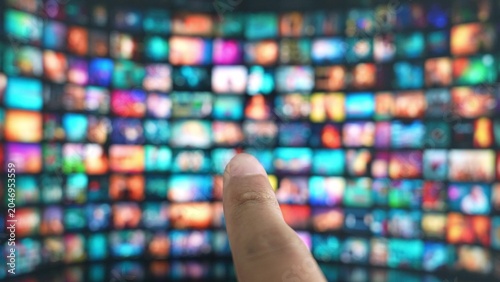 Photos A fingertip chooses content with gesture control on a giant TV, symbolizing touchless tech, interactive personalization, digital convenience, and the forward-looking evolution of home entertainment