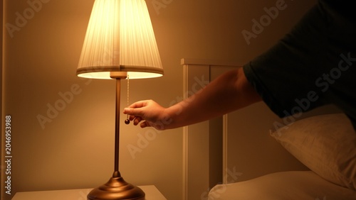 Bild auf Leinwand Turning off the soft yellow light in the bedroom marks the start of sleep, supports a healthy circadian rhythm, saves power, creates a peaceful mood, and reduces blue light exposure at night