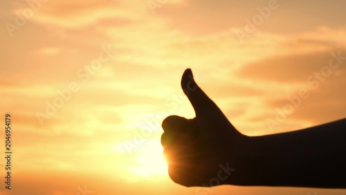 Foto The thumbs-up sign expresses support and satisfaction, shining in the warm evening light