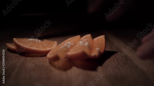 Hand Slicing Fresh Orange with Knife Close Up