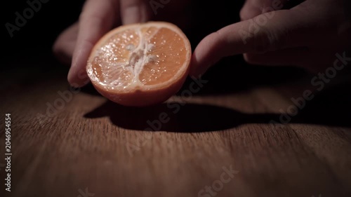 Hand Slicing Fresh Orange with Knife Close Up
