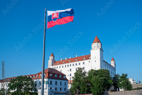 Canvas Print Slovak national flag waving above Bratislava Castle under a clear blue sky