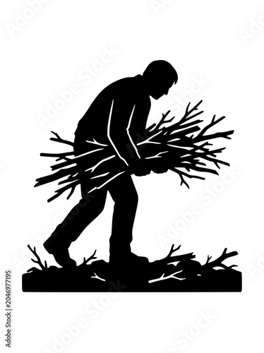 Silhouette of a man carrying a bundle of firewood branches