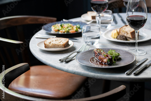 Fotografija Culinary Delights on a Stylish Dining Table at an Upscale Restaurant in the Even