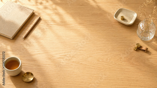 Wooden desk minimal workspace tea cup notebook pencil warm light shadow pattern brass object vase dried flower Copy space wooden desk with minimal