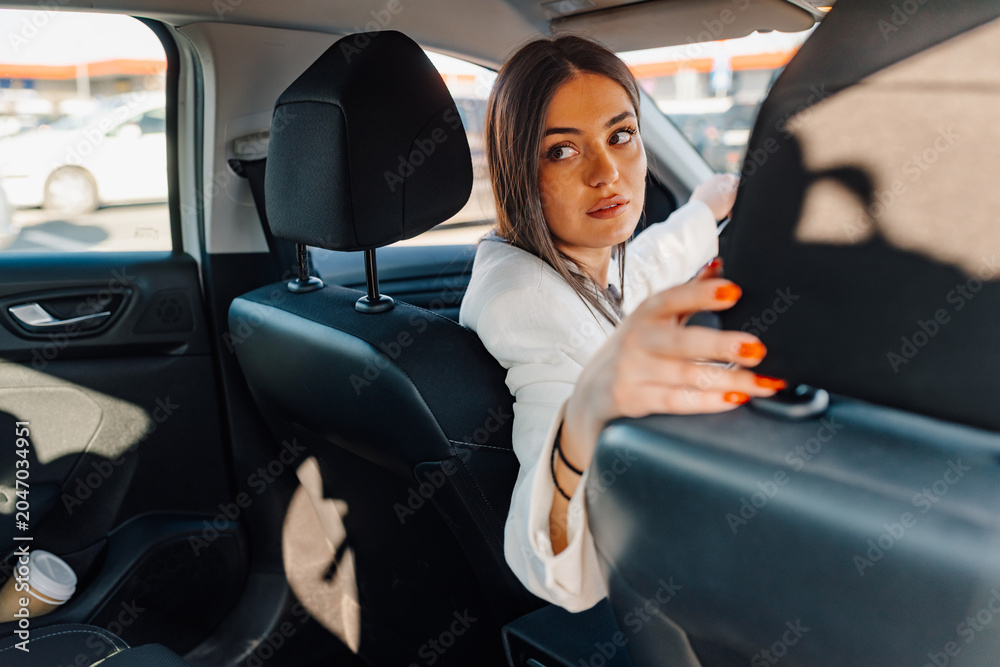 Fototapeta premium Woman reversing car looking back for safety