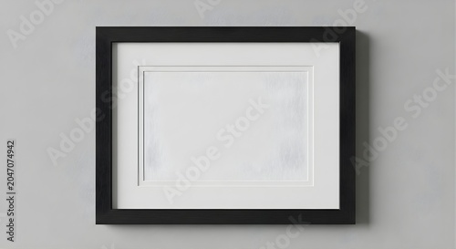 Blank black picture frame mockup on a grey wall.