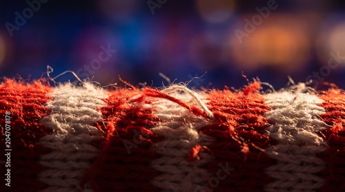 Frayed red and white wool knit fibers in night stadium lighting