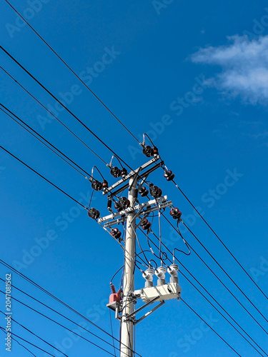 high voltage power lines against blue sky