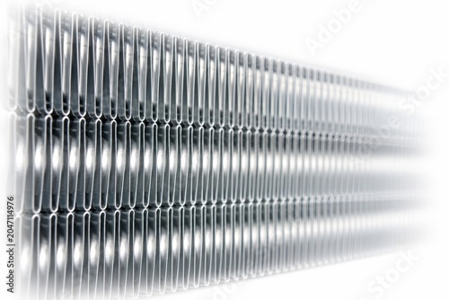 Clean metallic air conditioner evaporator fins repeating vertical geometric lines creating an abstract industrial texture soft depth of field fading smoothly