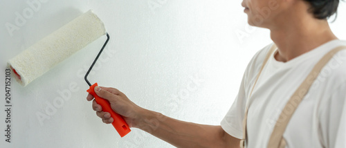 Fotografia painter man, brush in hand for products to restore and paint the wall, indoor th