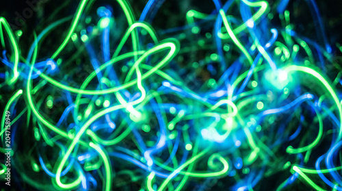 Background with glowing light blue and green lines, particles of data flowing in the air