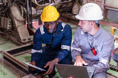 Industry engineer team worker work collaborating with laptop and clipboard while inspecting industrial machinery