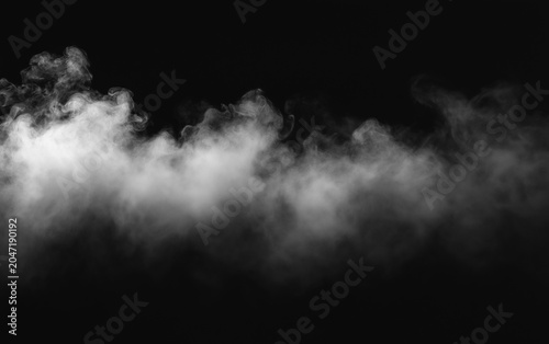Fotografie Abstract white smoke cloud drifting across a black background, creating a dramatic atmospheric mist texture with soft motion and high contrast