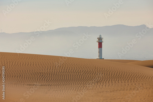 Picturesque lighthouse surrounded by dunes Fangar. Delta Ebro, Tarragona. Spain