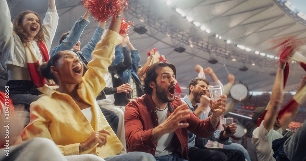 Naklejka premium Black Woman in a Yellow Shirt and a White Man With Red Cheek Paint Jump and Cheer With Soccer Football Championship Fans, WavingScarves From Crowded Stadium Seats During Play.