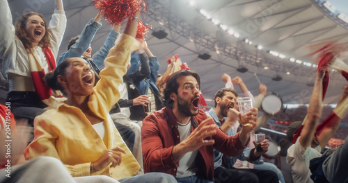 Black Woman in a Yellow Shirt and a White Man With Red Cheek Paint Jump and Cheer With Soccer Football Championship Fans, WavingScarves From Crowded Stadium Seats During Play.