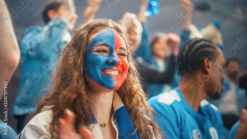 Foto Portrait of a Smiling White Female Spectator With Blue and Red Face Paint Enjoying a Soccer Football Championship Game, Diverse Crowd of Fans Applauding Their Team During a League Match in an Arena