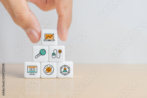 Hand stacks online marketing components as symbols on cubes