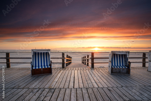 sunset on the wooden pier  with beach chairs