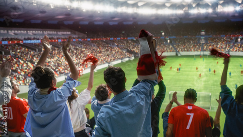 Bild auf Leinwand Back View of Diverse Excited Men and Women Waving Red Scarves and Pom-poms, Clapping Hands to Cheer Their Favorite Team Playing on the Pitch, Happy Soccer Fans at a Football Championship Stadium