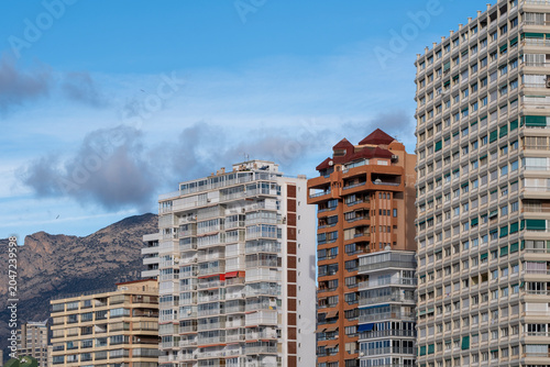 Along the coast, highrise apartments build the Benidorm, Spain skyline, where mountains, tourism architecture and beach light soften the towers