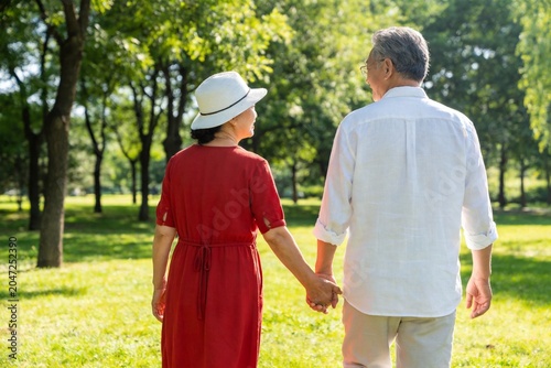 Elderly couple holding hands in park