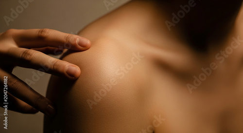 Close-up of a hand gently touching smooth skin on a shoulder, symbolizing care, connection, and intimacy, suitable for health or wellness concepts