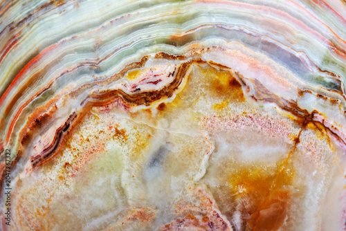Multicolored macro texture of an agate ball in close-up, showing its natural layered patterns and crystalline details