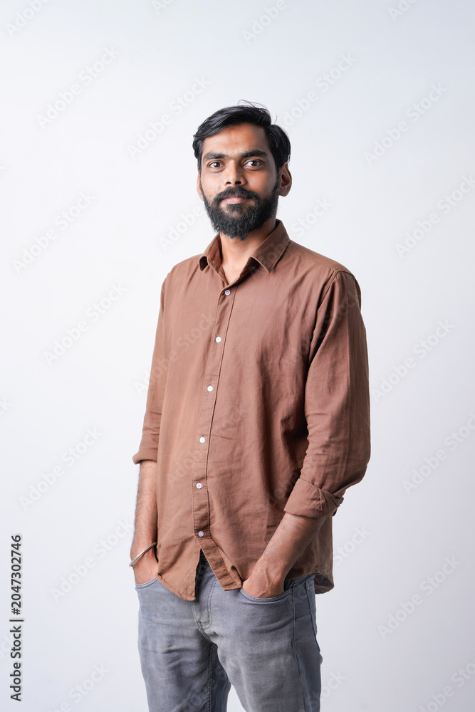 Fototapeta premium Young indian man standing confidently on white background
