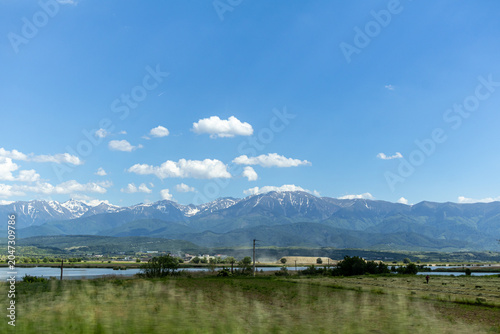 Panoramic Landscape of Snow Capped Mountains Under Blue Sky