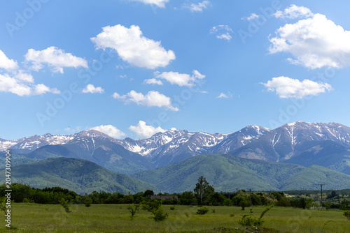 Beautiful Mountain Range Horizon View with Snow Peaks and Green Field