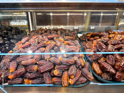 Close up of fresh premium dates arranged in a market showcase at an authentic Arabian food shop.