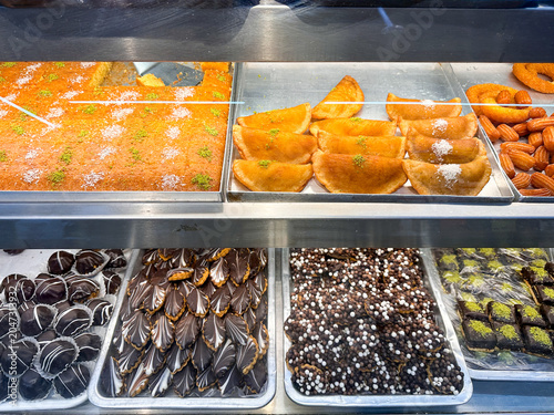 Selection of baklava, stuffed dates and traditional Arabian desserts showcased in a Dubai sweets market.