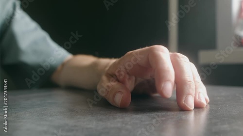 Close up man hand with fingers drumming nervously on dark table, expressing impatience, boredom, or anxiety while waiting for something or someone in room. Man tapping fingers showing impatience