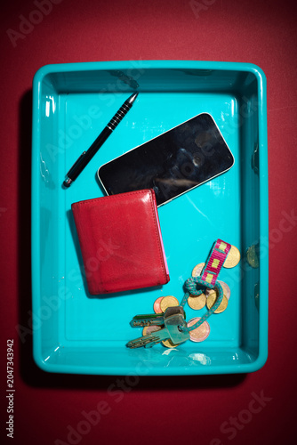 Personal belongings placed in the plastic tray at a security checkpoint.
