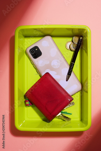Personal belongings placed in the plastic tray at a security checkpoint.