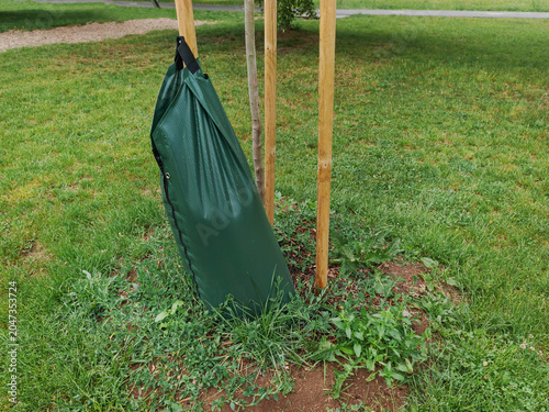 Green generic PVC tree watering bag is designed to slowly release water directly to the root system of newly planted trees
