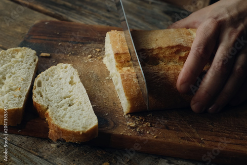 Foto Cutting freshly baked loaf of ciabatta bread