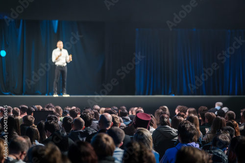 фотографія Business speaker on stage addressing large attentive audience at conference, corporate presentation, public talk and networking event