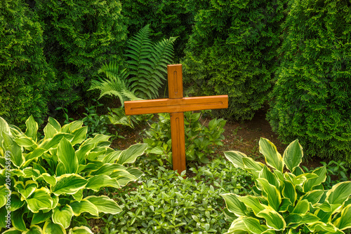 Wooden cross on the meadow. Christian concept of faith in God, divine truth, and the redemptive grace of Jesus