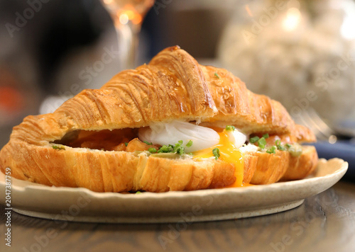 croissant with filling and poached egg for breakfast