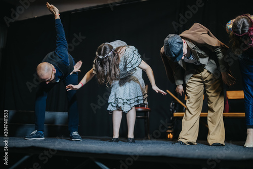 Canvastavla Young actors bow together at the front of a stage after finishing a play