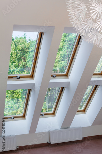 Obraz na płótnie Large skylights are installed in two rows in a bright and spacious attic room