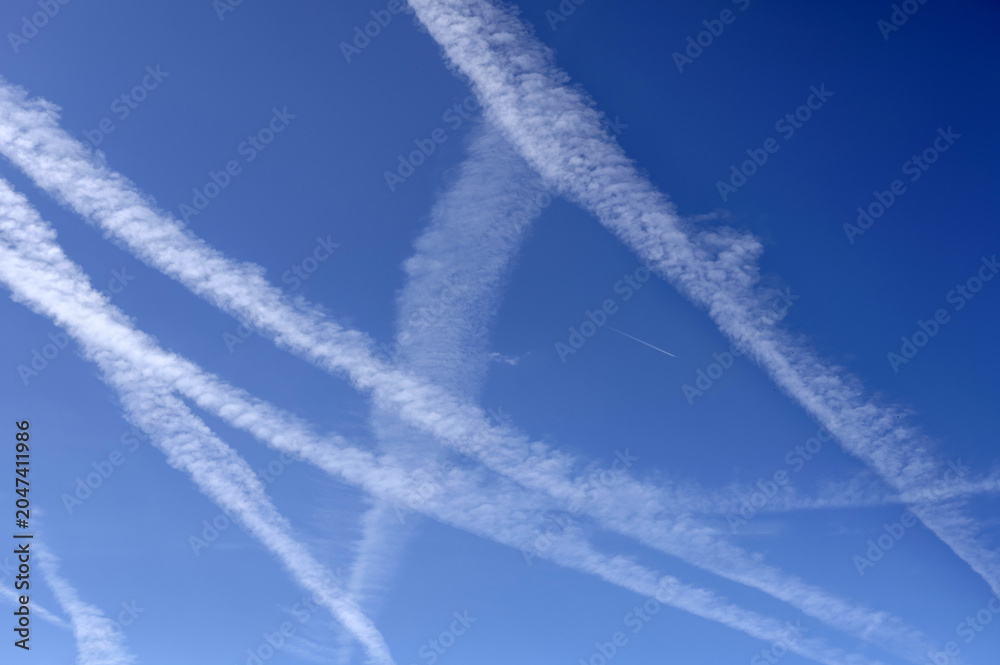 Naklejka premium Traînées de condensation sur fond de ciel bleu