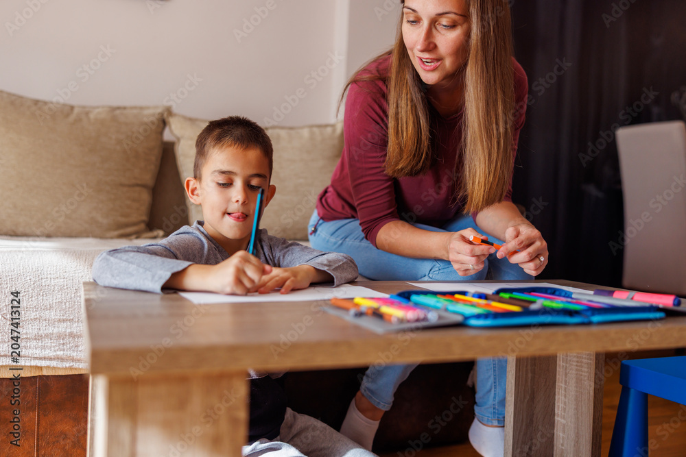 Naklejka premium Mother and son having fun drawing at home