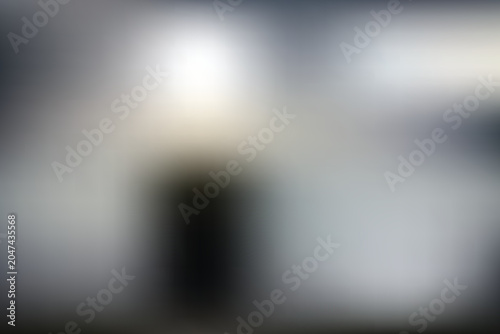 Obraz na plátně A blurry image of a person standing in a dark room with a bright light source
