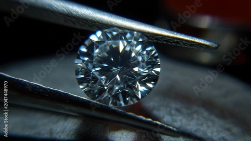 Laboratory grown diamond grading certificate held with tweezers for close inspection in a lab setting